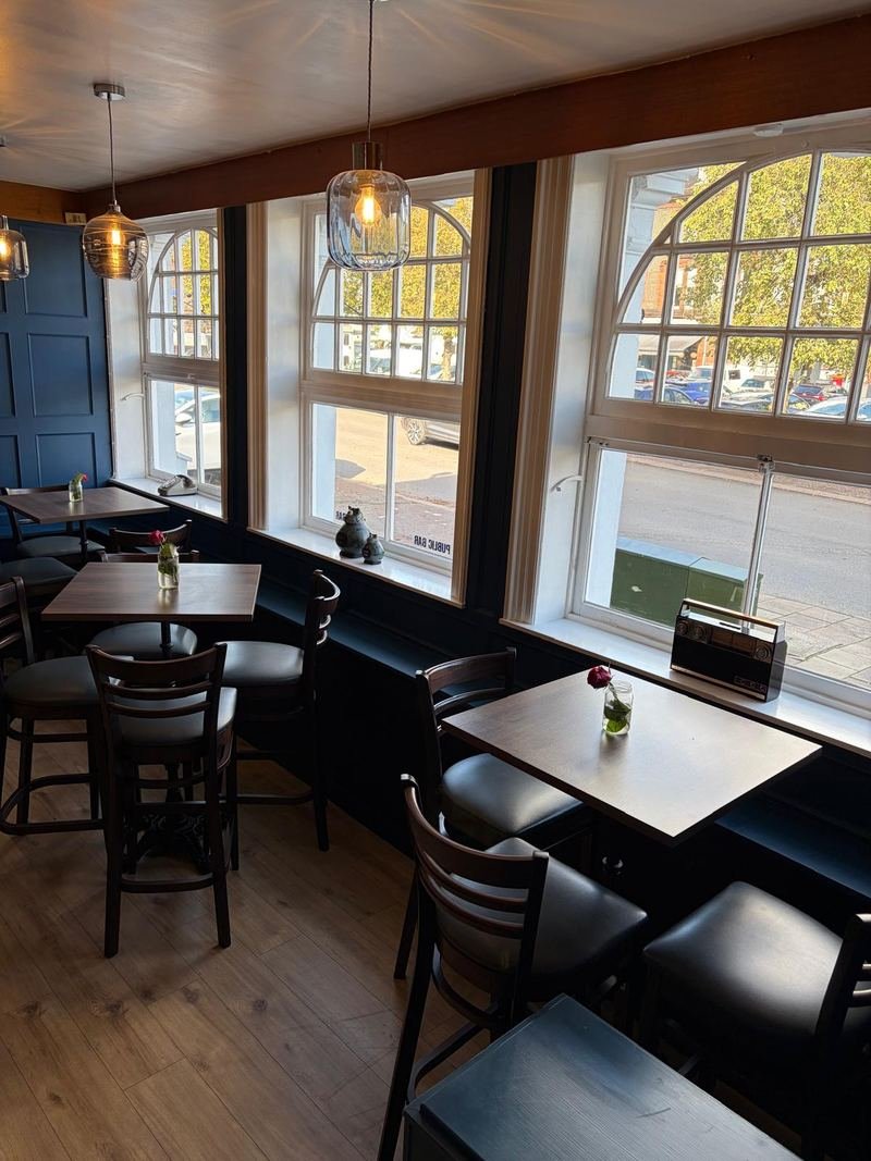 Tables by the arched windows of the bar