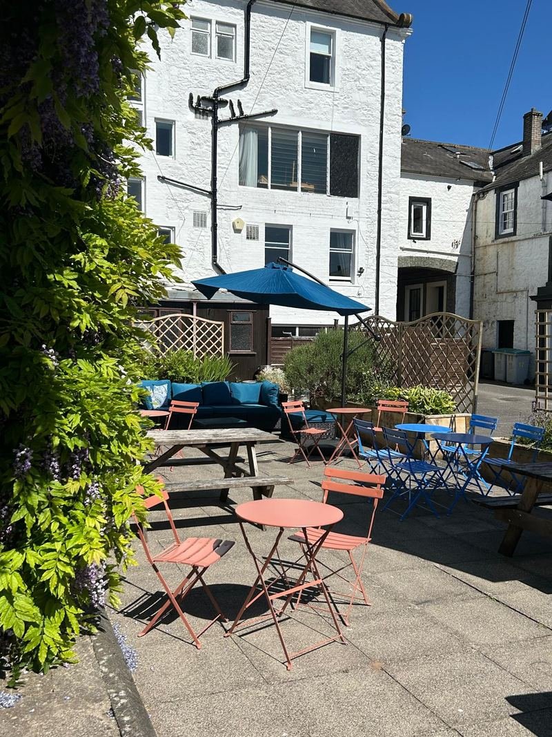 Small coral tables in the courtyard, wisteria on the wall