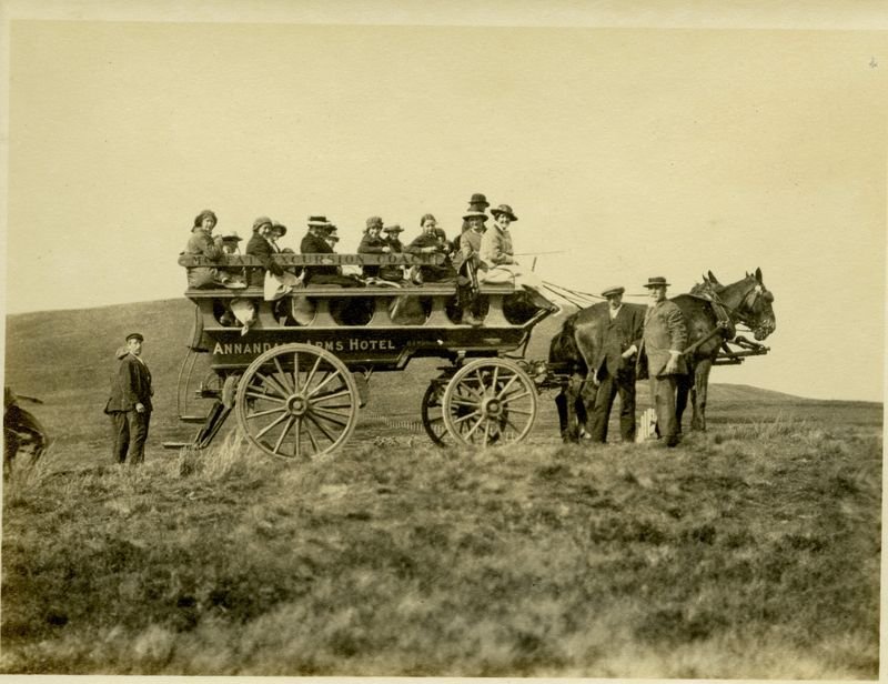 An old photograph of a horse drawn coach with Moffat Excursion Coach and Annandale Arms Hotel painted on the side