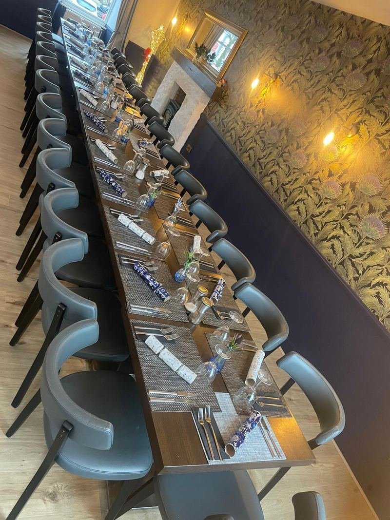 A long table laid for a party under the thistle wallpaper
