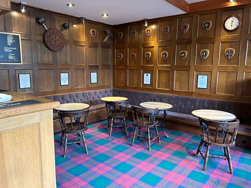The old panelled bar, with tartan carpet and wooden shields on the walls
