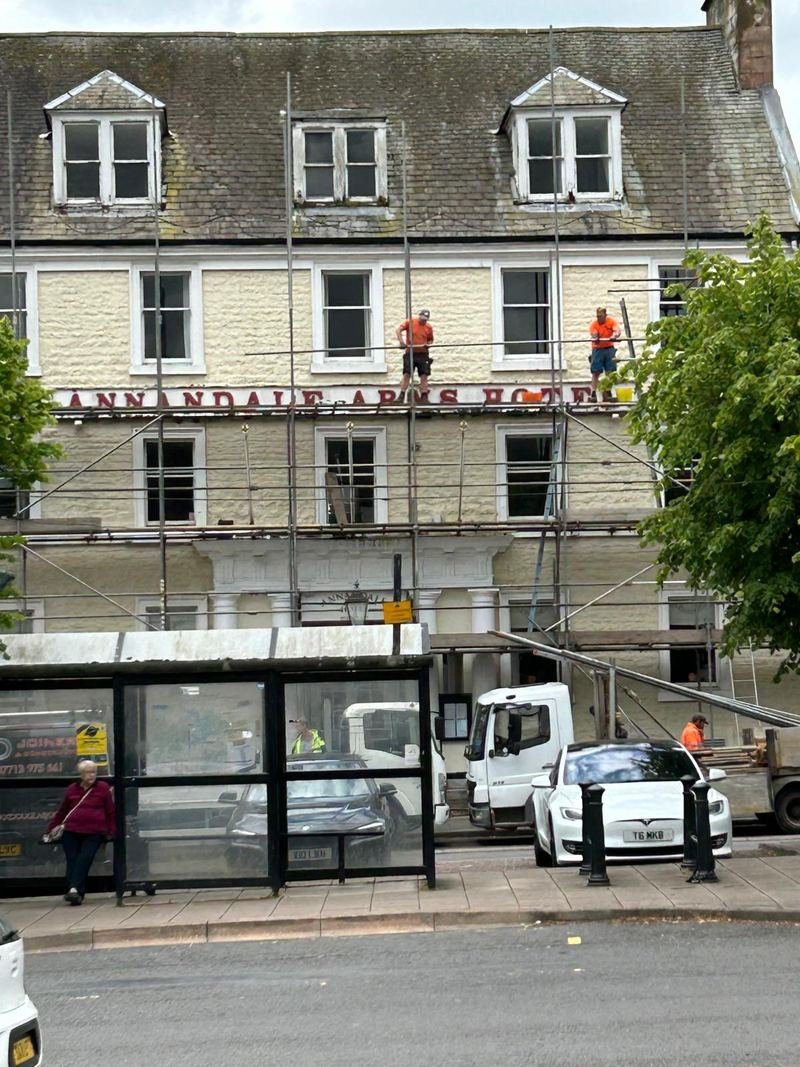Scaffolding across the front of the hotel, with workmen on it