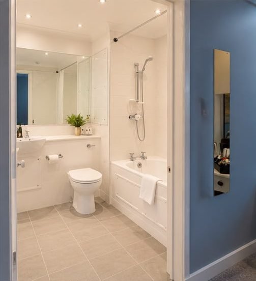 A white en-suite bathroom with a bath and shower