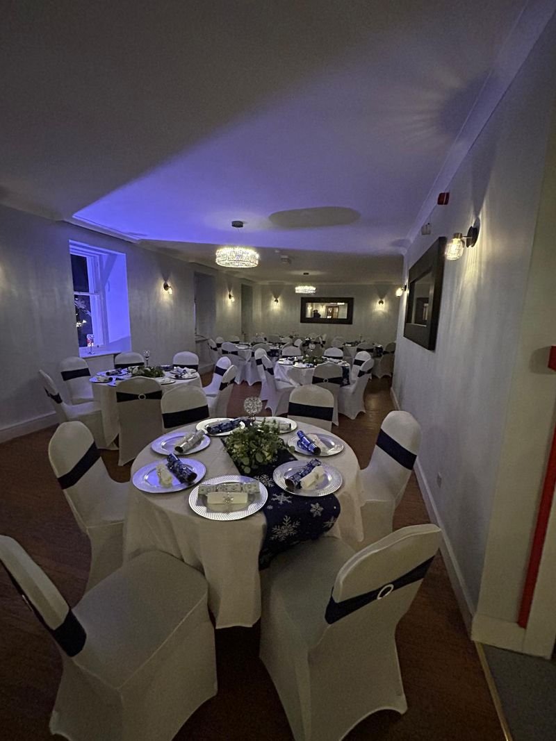 The function room in the evening, round tables under soft blue lighting